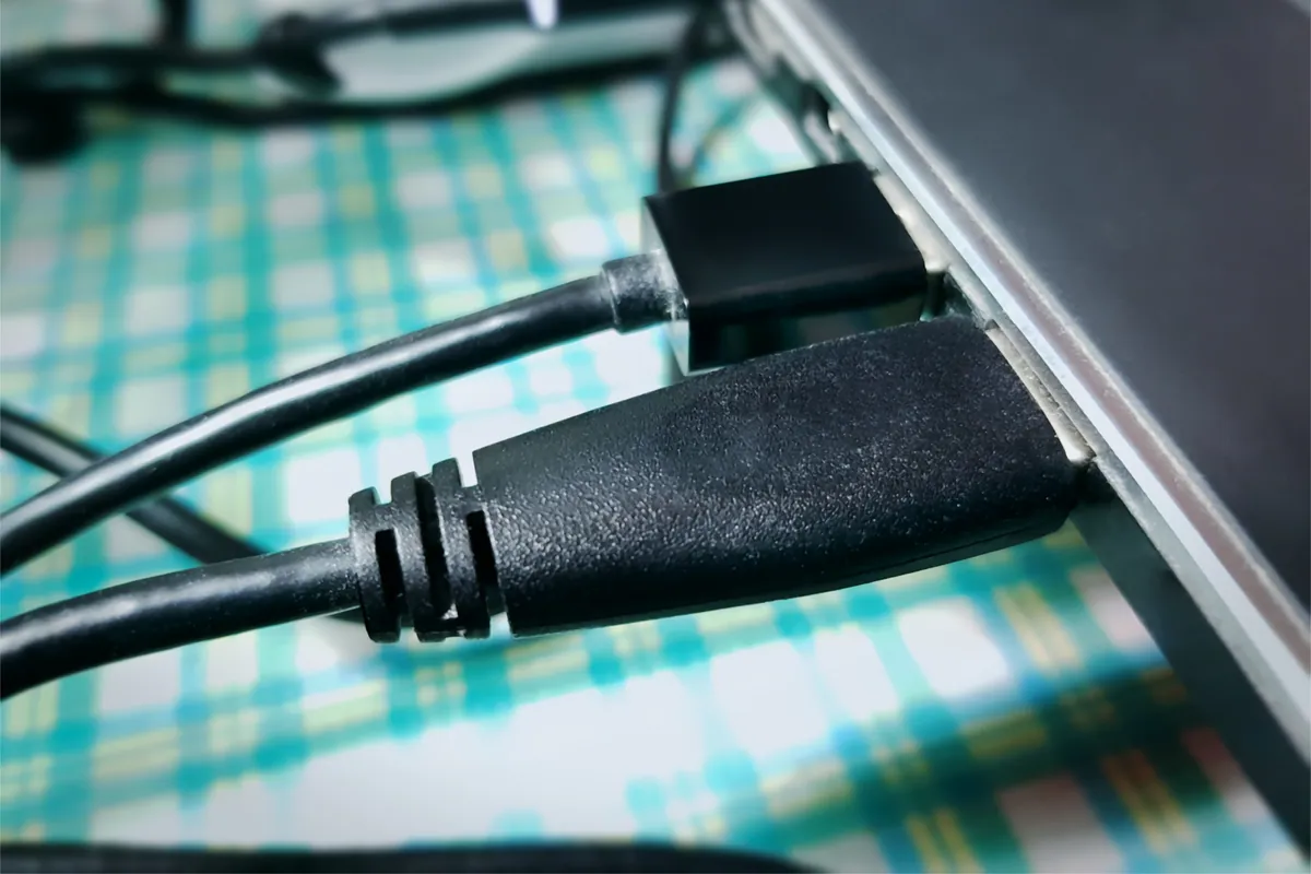Charging cable being plugged into the side port of a laptop